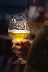 Woman's hand with a glass of beer tasting