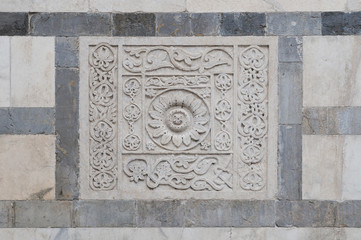 Bas-relief in white marble on the facade of the Carrara cathedral