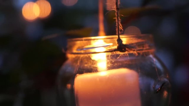candle in jar hanging on tree