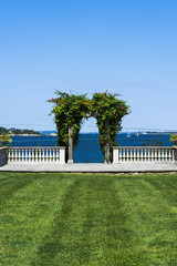 green lawn and arch with Newport Bay in background