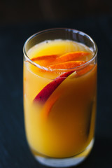 Mango and orange smoothie in transparent glass.