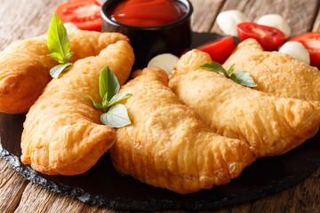 Italian fried donuts panzerotti close-up on a wooden table. horizontal