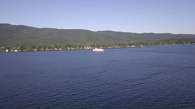 Drone aerial of a large sightseeing ferry boat on a lake in Lake George in New York.