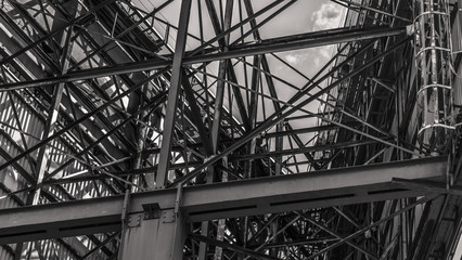 Metal structure of a huge road billboard, rusted metal and scraped paint in the scene. Black and white picture.