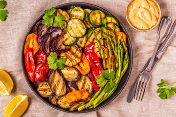 Grilled vegetables on a plate with sauce.