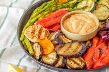Grilled vegetables on a plate with sauce