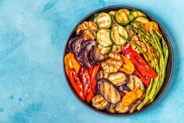 Grilled vegetables on a plate with sauce.