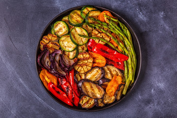 Grilled vegetables on a plate with sauce.