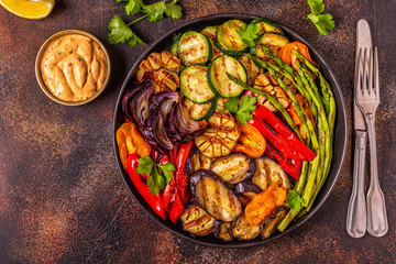 Grilled vegetables on a plate with sauce.