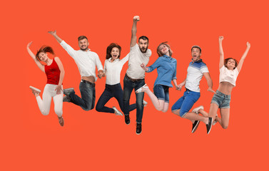 Freedom in moving. Mid-air shot of pretty happy young man and women jumping and gesturing against studio background. Runnin girl in motion or movement. Human emotions and facial expressions concept