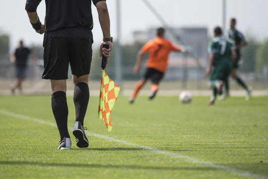 Legs of assistant of football referee with the flag