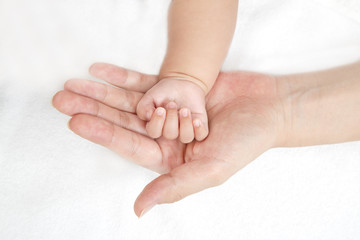 Obraz na płótnie Canvas 新生児の小さな手包むように乗せたお母さんの大きな手、愛情、母性イメージ