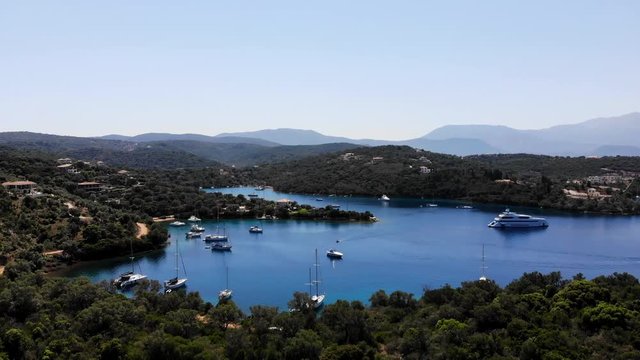 Aerial view overlooking bay before panning down to single boat in opposing bay