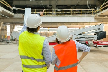 Man engineer and woman architect at a construction site. Building, development, teamwork and people concept