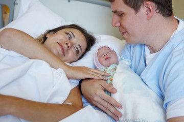 Young parents together with a newborn daughter.
