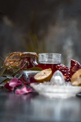 Close up of herbal face pack of pomegranate and lemon juice with rose water on wooden surface with some sliced lemons and pomegranates used for Dull skin.