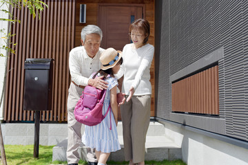 帰宅した孫娘を出迎えるシニア夫婦