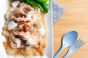 Fried noodles with pork , squid , shrimp and kale in gravy sauce