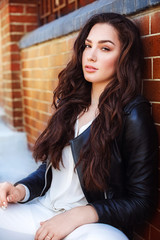 Fototapeta premium Portrait of beautiful young brunette girl with makeup in black fashion clothes 