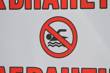 No Swimming sign. Red and black No swimming danger sign. Prohibitive sign “No swimming”. Danger sign