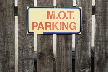 MOT parking sign on fence at garage car park