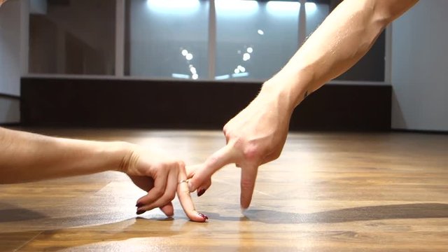 Young handsome man and woman dancer performs moves in dance studio