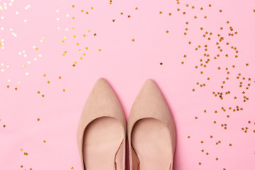 female shoes with heels and shiny confetti on a colored background. Women's shoes.