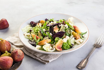 Salad with figs on a gray stone background