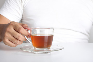 Fat man holding a glass of hot tea A healthy herb.