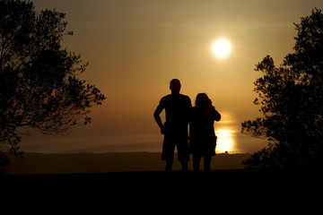 Fototapeta na wymiar Eine Frau und ein Mann schauen sich den Sonnenaufgang an