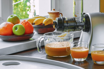 The gray horizontal juicer on the table squeezed orange fresh. Concept - a healthy lifestyle,...