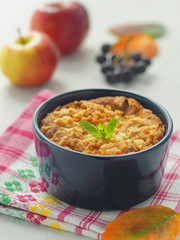 Fresh coffee cake with apples, rowan berry, fresh mint and bright leaves. Vertical. Selective focus on the mint leaf.