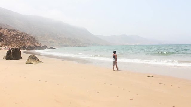 Woman Walking to the Ocean in Imsouane, Morocco
