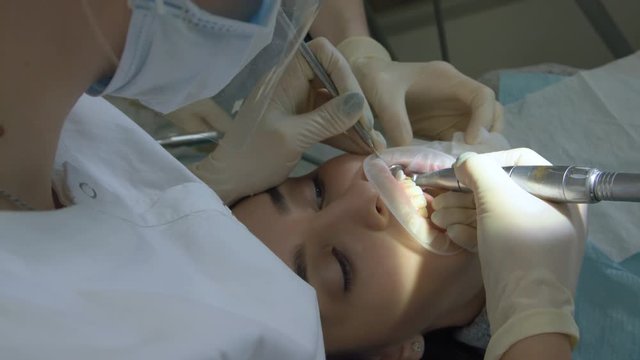 Visit To The Dentist. Orthodontist Doctor Sets Up Iron Braces For A Young Woman