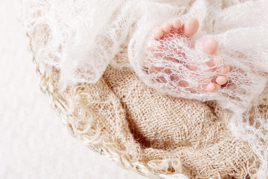 Newborn baby feet on knitted plaid. Closeup picture