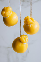 Scamorza cheeses are hanged together in strings to ripen on marble background