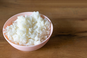 A cup of Steamed rice. put on  wooden table.