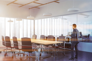 Fototapeta premium Businessman in panoramic meeting room corner, wood