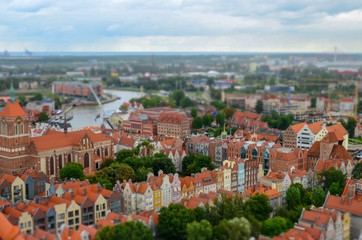Fototapeta na wymiar City of Gdansk in Poland, aerial view over the Old Town, view from Saint Mary's Church Tower. Cityscape of Gdansk at cloudy day. Miniature effect. Selective focus
