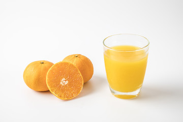 Orange fruit and glass of juice isolated on white background