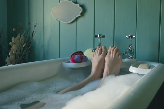 Woman taking bath in bathtub at bathroom