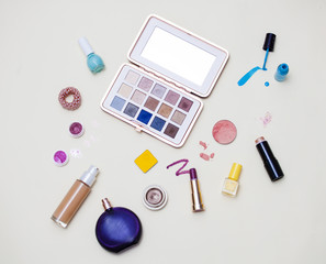 Expanded decorative cosmetics and a bottle of perfume: lipstick, pallet with shadows, blush and...