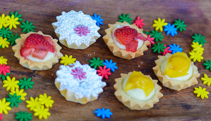 multiple colorful cupcakes of different flavors on a colorful background