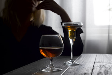 silhouette of anonymous alcoholic woman person drinking behind glass of alcohol. Alcohol addiction and Social problem - with alcoholism and poisoning