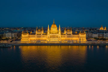 Fototapeta na wymiar Budapest, Hungary - Aerial blue hour view of the illuminated Parliament of Hungary reflecting on River Danube with St.Stephen's Basilica at background