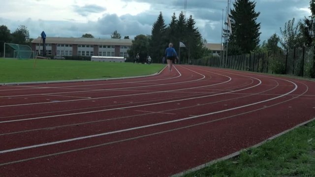 Girl starts running on a track in Oslo, Norway.