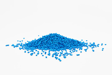 Stack of a blue plastic polymer granules on a white background, copy space - obrazy, fototapety, plakaty