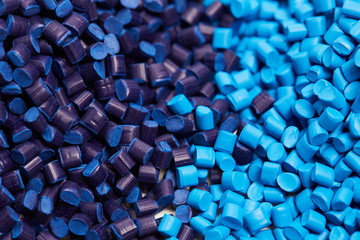 Close up of a two stacks of blue plastic polypropylene granules on a table - obrazy, fototapety, plakaty