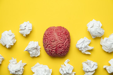 Brainstorming ideas. Brain with crumpled paper on a yellow background.