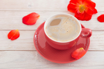cup of coffee with red flowers on white wooden table